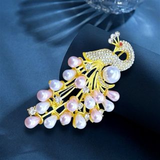 Đây là một chiếc trâm cài áo hình con công thanh lịch, thường được làm từ hợp kim mạ vàng, đính kèm ngọc trai (có thể là ngọc trai nuôi cấy hoặc ngọc trai nước ngọt) và các viên đá pha lê hoặc zircon lấp lánh. Kích thước 7cm