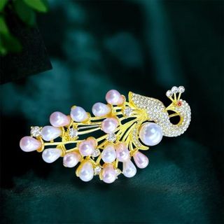 Đây là một chiếc trâm cài áo hình con công thanh lịch, thường được làm từ hợp kim mạ vàng, đính kèm ngọc trai (có thể là ngọc trai nuôi cấy hoặc ngọc trai nước ngọt) và các viên đá pha lê hoặc zircon lấp lánh. Kích thước 7cm